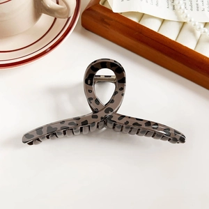 Detail of premium leopard print hair claw clip with glossy brown finish and golden spring
