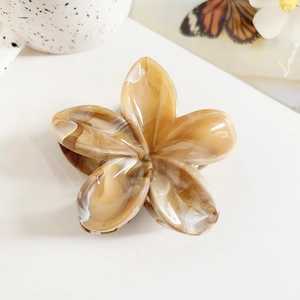 Detailed close-up of marble pattern plumeria hair claw clip in coffee and cream tones