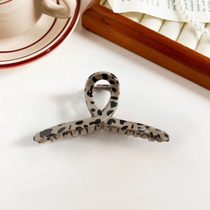 Detail shot of leopard print hair claw clip styled with vintage pearls and coffee theme