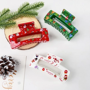 Détail de trois pinces à cheveux de Noël avec des motifs de Père Noël, bonhomme de neige et sapin