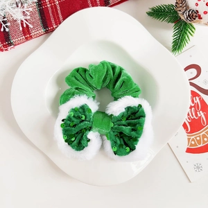 Dettaglio dell'elastico natalizio in velluto verde con fiocco di paillettes e pelliccia