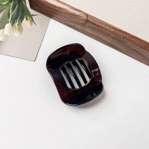 Detail shot of a dark brown translucent square hair claw clip on a white background