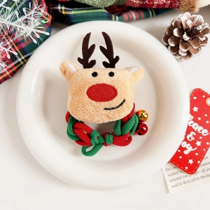 Détail d'un chouchou de Noël en peluche renne avec clochettes sur une assiette décorative