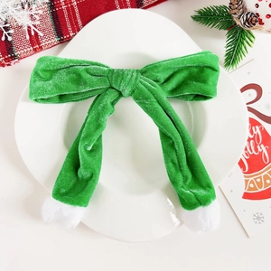 Dettaglio dell'elastico per capelli in velluto verde natalizio con pompon in ecopelliccia