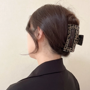 Classic brown leopard print hair claw clip shown on a model for elegant hair styling