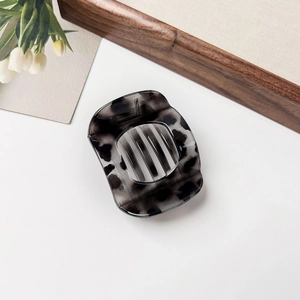 Detailed view of large dark grey leopard print resin hair claw clip for thick hair styling