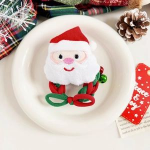 Détail d'un chouchou de Noël avec broderie du Père Noël et de petits grelots colorés