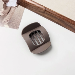 Close-up of large matte coffee brown claw clip with sturdy inner teeth for thick hair