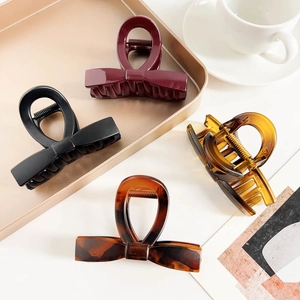 Set of four elegant bow hair clips in burgundy, black, amber, and tortoiseshell finish