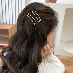 Elegantes Haarspangen-Set mit Leopardenmuster auf braunem Haar vor minimalistischer Wand