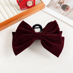 Detailed view of a large burgundy velvet double bow hair claw clip for elegant hairstyles