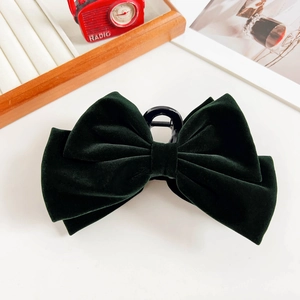 Close-up of a large dark green velvet double-layer bow hair claw clip for women