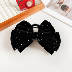 Close-up of black velvet bow hair claw clip with sparkling rhinestones details