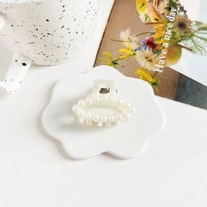 Detailed macro view of 4cm pearl hair claw clip with metallic spring mechanism