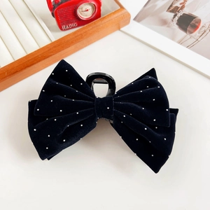 Close-up of black velvet bow hair claw clip with silver rhinestones on white background