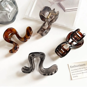 Close-up of geometric acetate hair claws in tortoiseshell and translucent grey tones