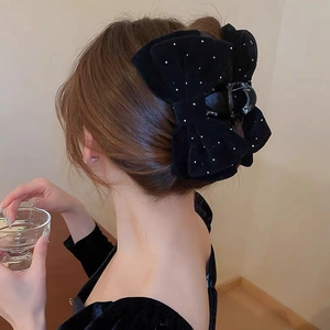 Elegant black velvet bow hair claw clip with rhinestones shown on model from the back