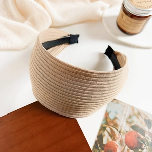 Detail of khaki ribbed knit wide headband showing soft pleated fabric texture and interior frame