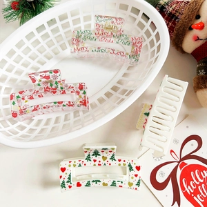 Set of four large Christmas claw clips with festive prints in white, red, and green