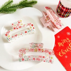 Detailed view of Christmas hair clips featuring snowflake, tree and Santa Claus prints