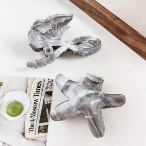 Detail of acetate marble hair clips in ginkgo and starfish shapes with smooth finish