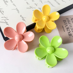Vue détaillée des pinces à cheveux en forme de fleur aux couleurs pastel avec éclat