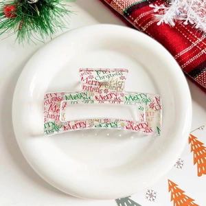 Detail of Christmas hair claw with Merry Christmas text and snowflake patterns