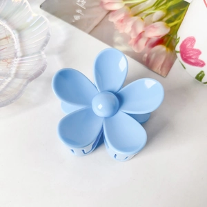 Détail d'une pince à cheveux fleur bleue de 7,5cm au fini résine brillante