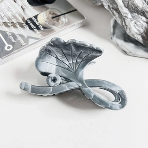Close-up of a ginkgo leaf hair claw clip with a grey and white marble pattern texture