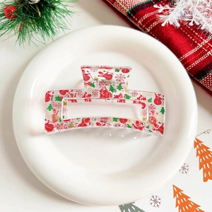 Detail view of transparent Christmas hair claw with festive snowman and tree prints