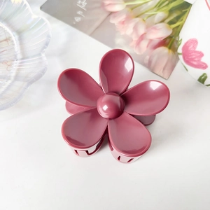 Vue détaillée d'une pince à cheveux fleur rose sur un plateau décoratif chic