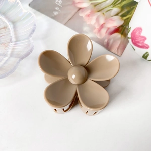 Détail d'une pince à cheveux fleur mate de 7,5 cm sur un fond blanc au style minimaliste