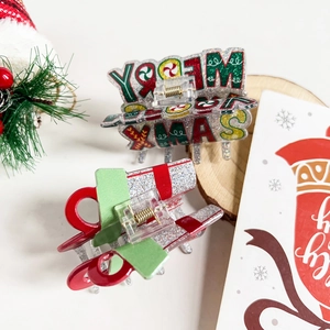 Christmas hair claws with Merry Xmas glitter text and red green festive bow designs