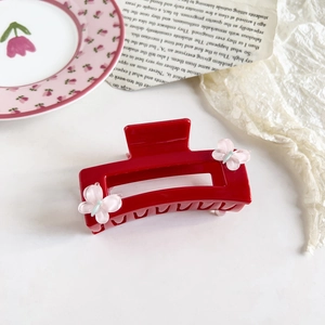 Close-up of red rectangular hair claw clip with pink resin butterfly decorations