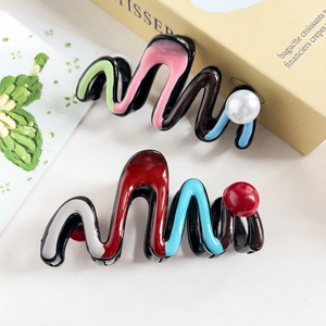Close-up of zigzag resin hair claws with faux pearl accents in vibrant colors