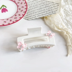 Detailed view of white square hair claw clip with pink butterflies and blue beads