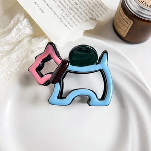 Detailed macro view of a colorful dopamine dog-shaped hair claw clip on a ceramic tray