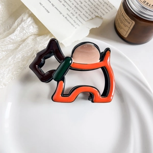 Close-up of a Scottie dog hair claw clip in orange and black high-gloss acetate