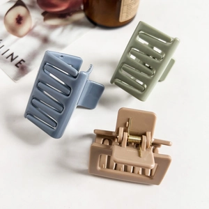 Three matte square hair claws in blue, green, and brown with gold metal springs