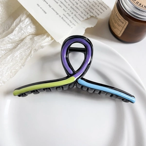 Detail of the dopamine-style dog hair claw clip with colorful striped accents