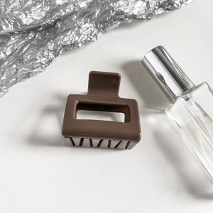 Detail view of a premium coffee brown rectangular claw clip with smooth resin finish