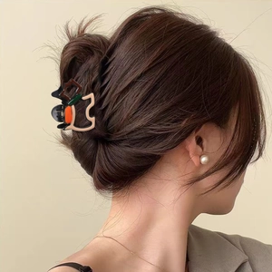 Color-block geometric hair claw clip in resin, styled on a hair bun with a vintage look