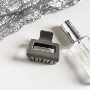 Macro detail of the grey hollow rectangular hair claw clip with smooth polished finish