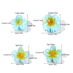 Set of four blue and yellow frangipani hair clips with size and weight dimensions