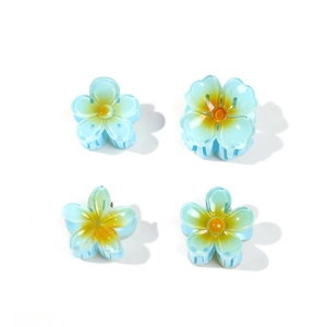 Set of four blue frangipani flower hair clips with yellow center for beach vacation styling