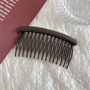 Detailed view of dark brown matte 15-tooth hair comb with curved anti-slip design