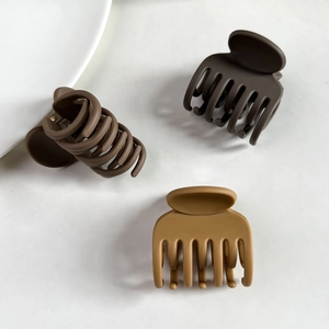 Vue macro de trois pinces à cheveux marron mat avec un design à sept dents