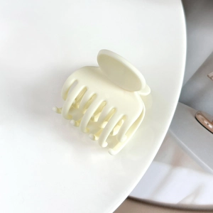 Détail de la pince à cheveux crème mat à 7 dents montrant la finition lisse et arrondie