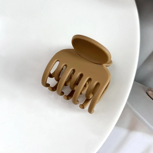 Gros plan détaillé de la pince à cheveux mate brun caramel à sept dents pour coiffure