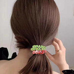 Christmas themed spiral hair ties in red and green with holiday patterns on ponytail
